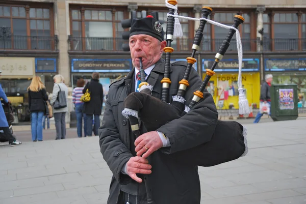 stock image Scottish Bagpiper in plaid and kilt with the Bagpipe, Princess Street, Edin