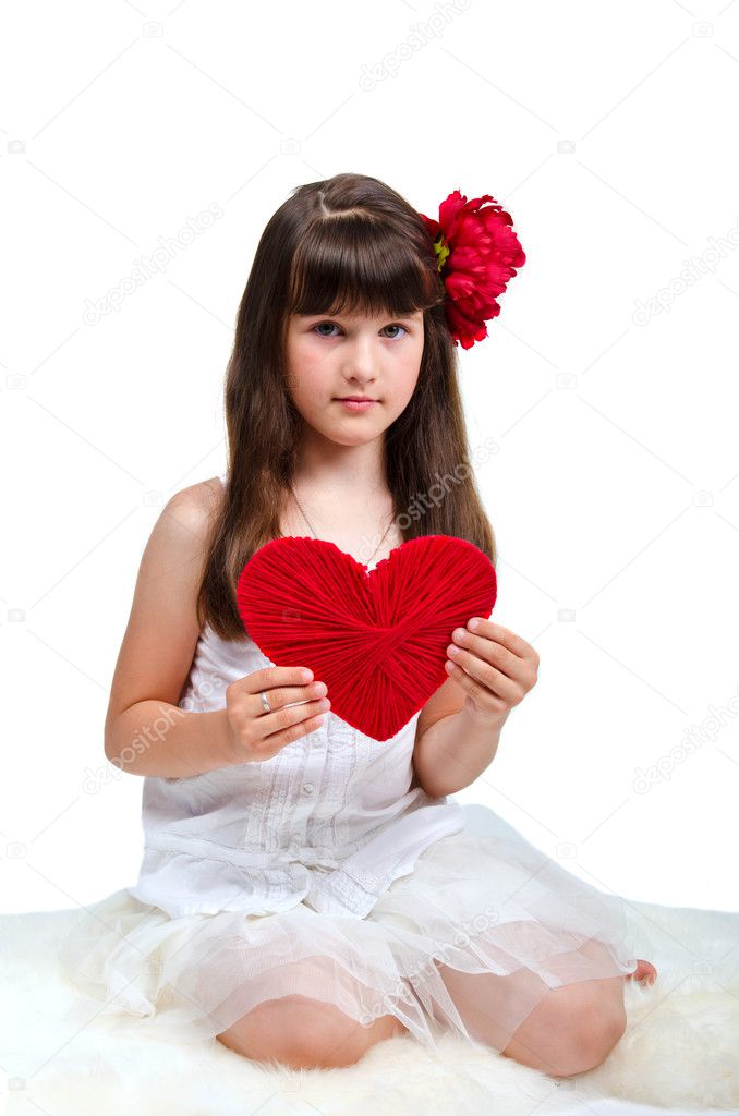 Brunette girl wearing white dress holding red heart in her hands