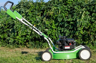 Lawn mower in the garden clipart