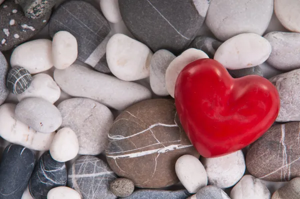 Coração vermelho entre pedras de seixos — Fotografia de Stock