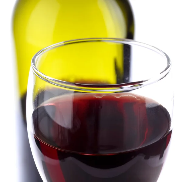 Sklenici červeného vína s pozadím láhev vína — Stock fotografie
