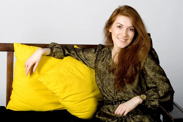 Studio porträtt av en dam som sitter på en soffa — Stockfoto