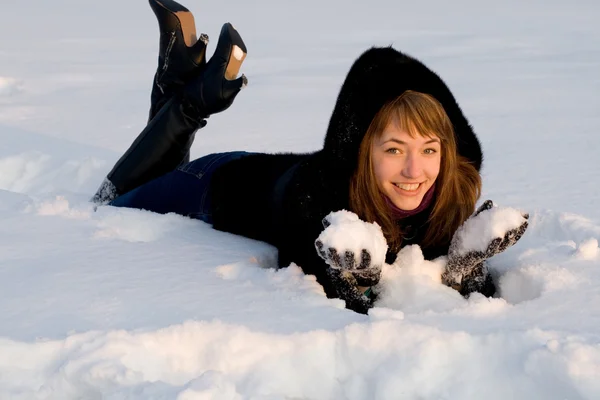 Porträtt av en flicka liggande på snö fältet — Stockfoto