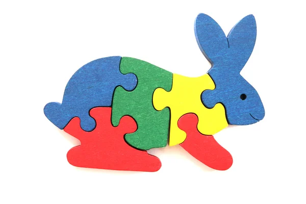 Puzzle in legno colorato a forma di coniglio su sfondo bianco — Foto Stock