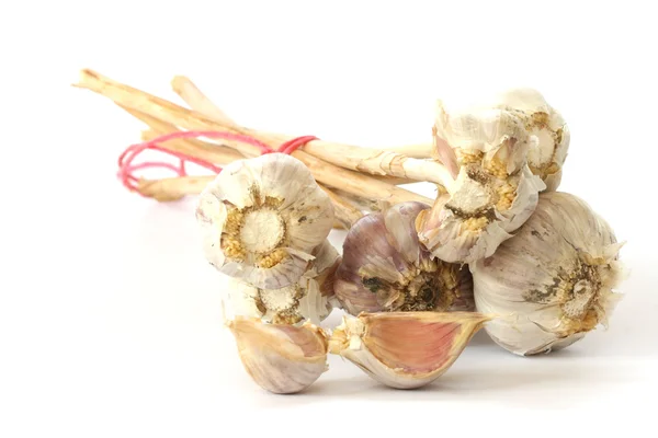 Poucas cabeças de alho e dentes de alho no fundo branco — Fotografia de Stock