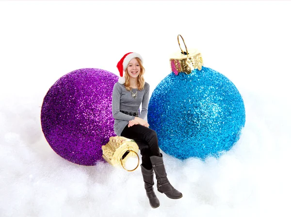 Girl sitting on Christmas balls — Stock Photo, Image