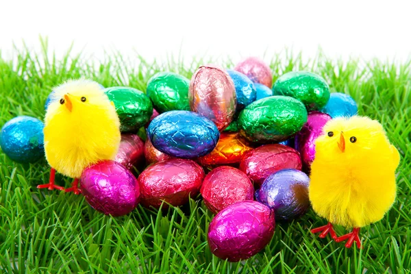 Kurczaki wielkanocne i kolorowe jaja na trawie — Zdjęcie stockowe
