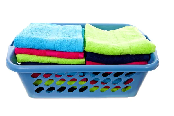 Cesta de lavanderia cheia de toalhas coloridas — Fotografia de Stock