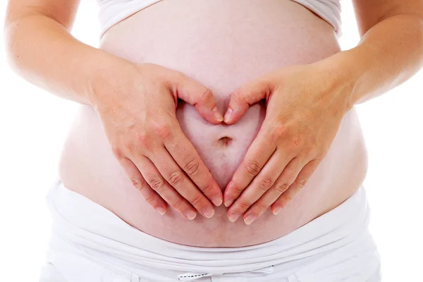 Vientre embarazada con las manos en forma de corazones — Foto de Stock