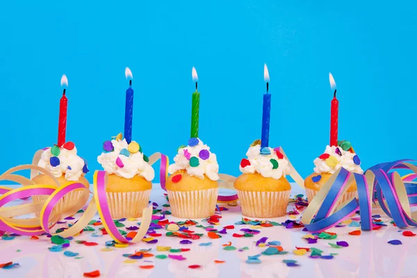 Verjaardag cupcakes met kaars slingers en kleurrijke confetti — Stockfoto