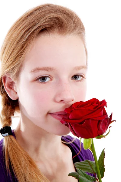 年轻女孩嗅到的特写镜头中的一朵红玫瑰 — 图库照片