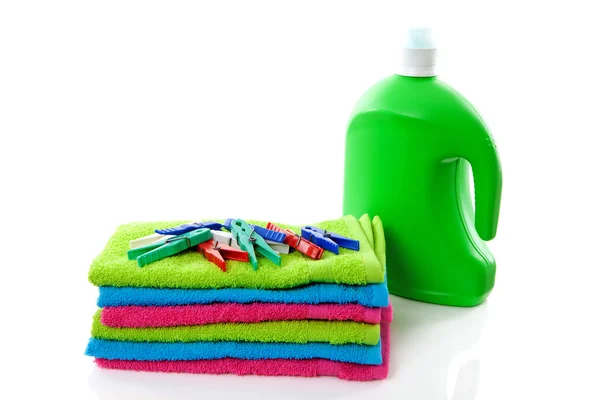 Coloridas toallas dobladas, clavijas y botella — Foto de Stock