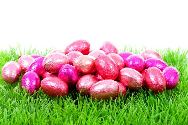 Пасхальные яйца из розового шоколада на траве — стоковое фото