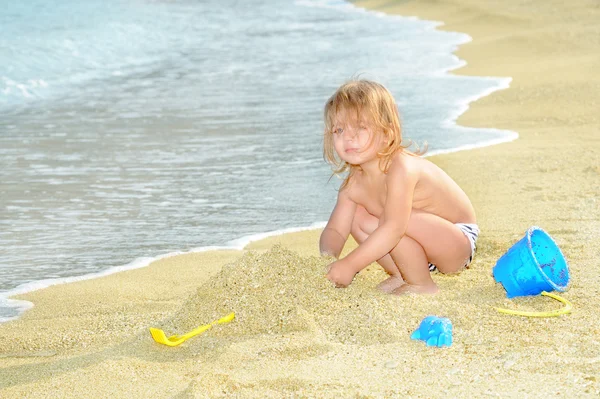 Szczęśliwe dziecko na plaży gry z jej zabawki — Zdjęcie stockowe