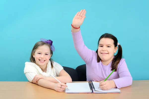 Två tjejer gör deras skolarbete i klassrummet — Stockfoto