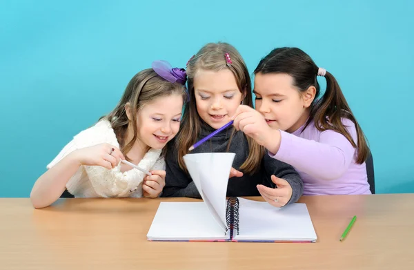 Trois filles heureuses faisant leur travail scolaire — Photo