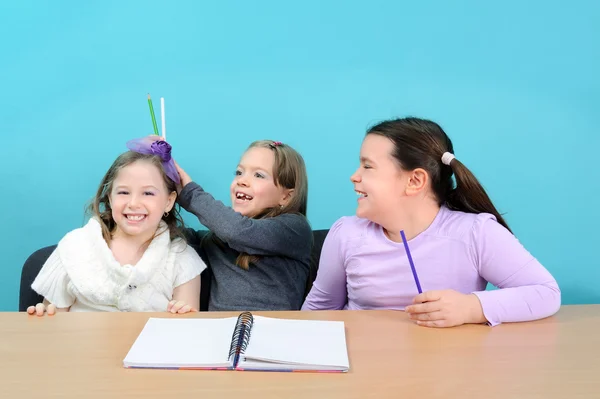 Feliz escuela niñas haciendo chistes en el aula —  Fotos de Stock
