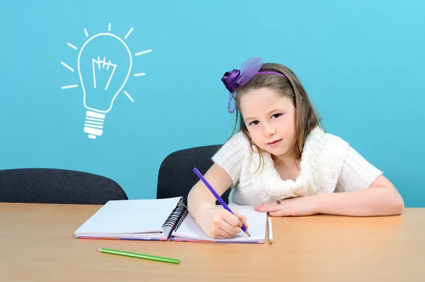 Chica joven y feliz haciendo su trabajo escolar — Foto de Stock