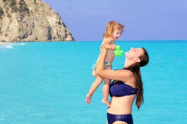 Gelukkig moeder met haar dochter op het strand — Stockfoto