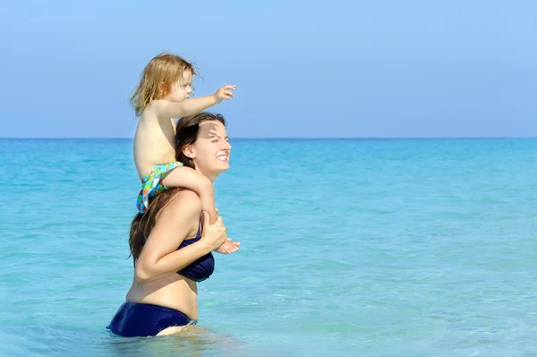 Felice bambino con sua madre sulla spiaggia — Foto Stock