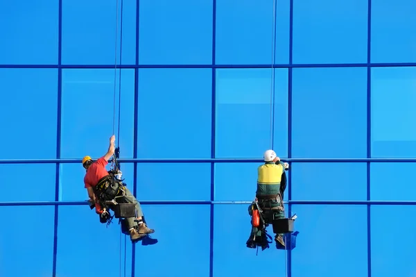 Dois wahsers lavar as janelas da fachada — Fotografia de Stock