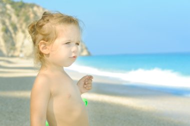 Young and happy toddler girl at the beach clipart