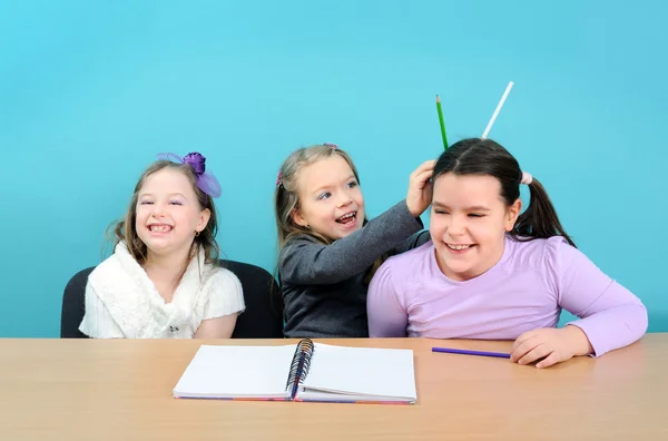 Три счастливые девушки шутят во время уроков в школе — стоковое фото