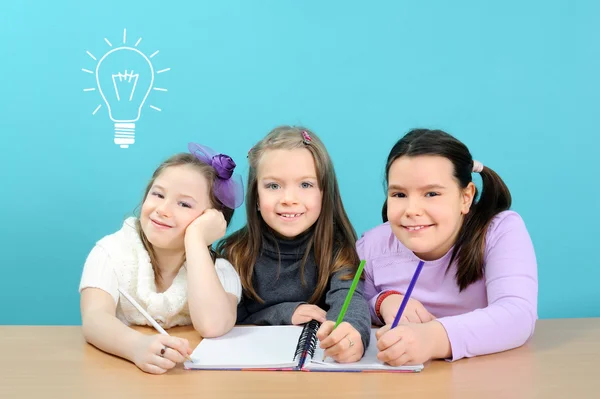 Gelukkig schoolmeisjes doen hun werk in de klas — Stockfoto