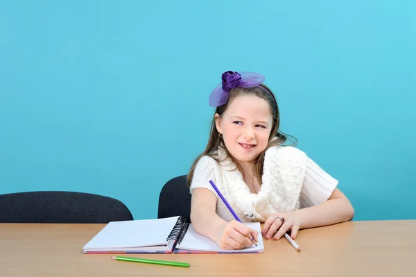 Usmívající se dívka dělá její školní práce — Stock fotografie