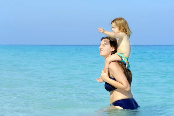 Šťastné dítě s matkou na pláži — Stock fotografie