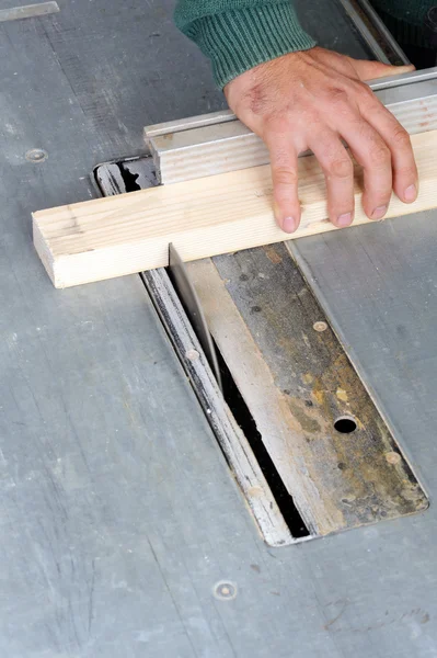 Carpenter cutting wood on electric saw — Stock Photo, Image