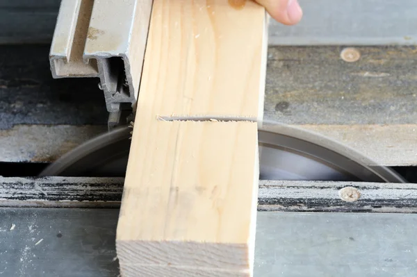 Carpenter cutting wood on electric saw — Stock Photo, Image
