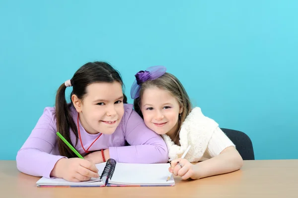 Duas meninas felizes fazendo seu trabalho na escola — Fotografia de Stock