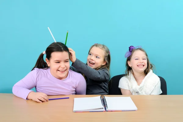 Tres chicas felices haciendo chistes durante la clase en la escuela —  Fotos de Stock