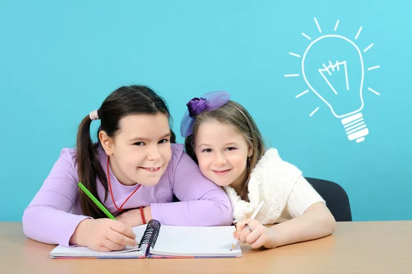 Twee gelukkige meisjes doen hun schoolwerk — Stockfoto