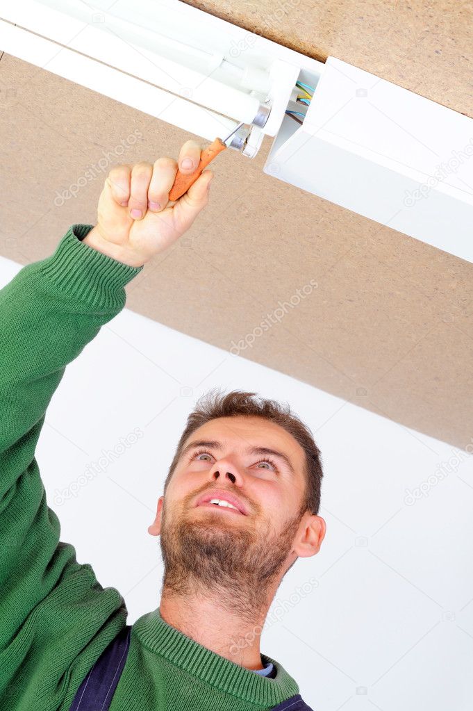 Electrician fixing ceiling light
