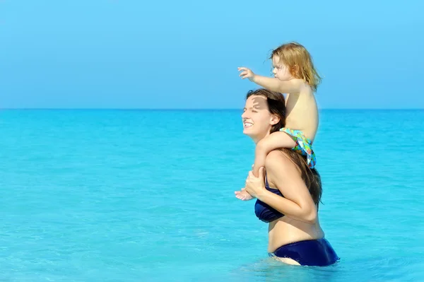 Gelukkig kind met haar moeder op het strand — Stockfoto