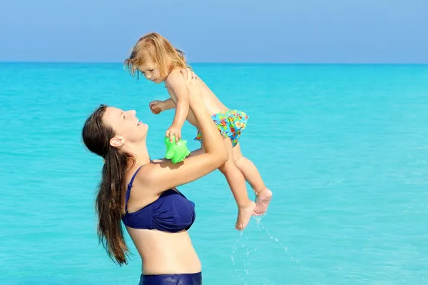 快乐的孩子与她的母亲在海滩上 — 图库照片