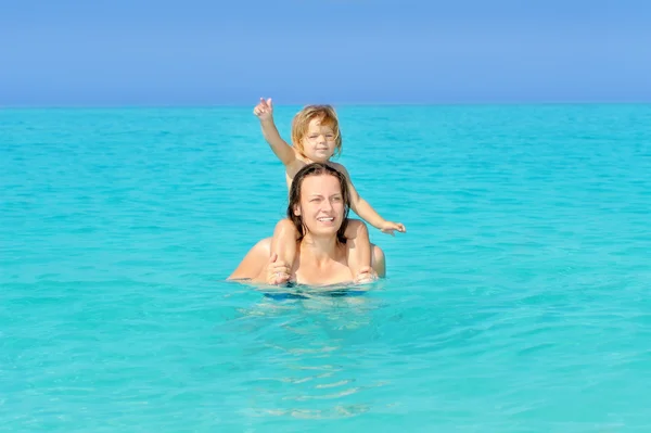 Glada barn med sin mor på stranden — Stockfoto