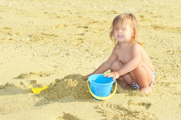 Happy child on the beach playing with her toys — Stock Photo, Image