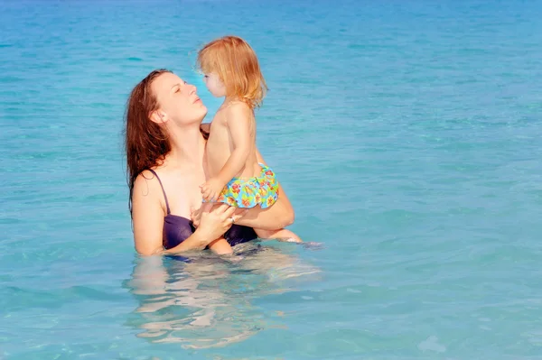 Criança feliz com sua mãe na praia — Fotografia de Stock