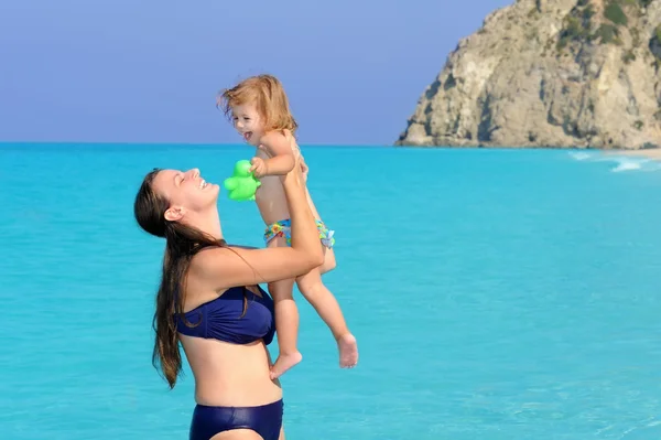 Счастливая мать с дочерью на пляже — стоковое фото