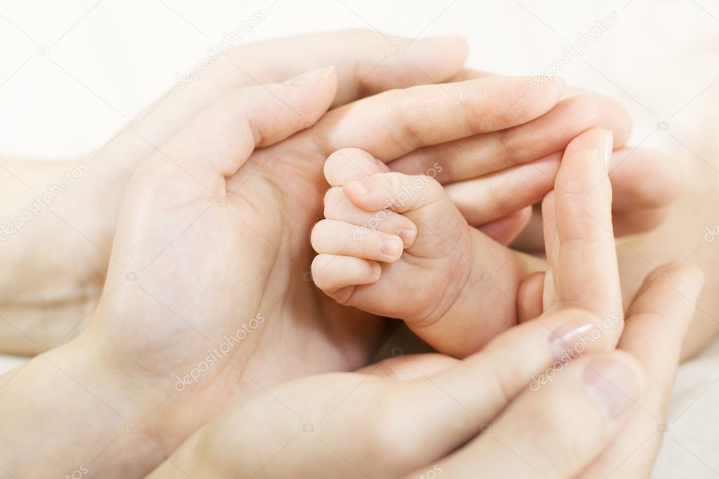 Baby hand into parents hands. Family concept