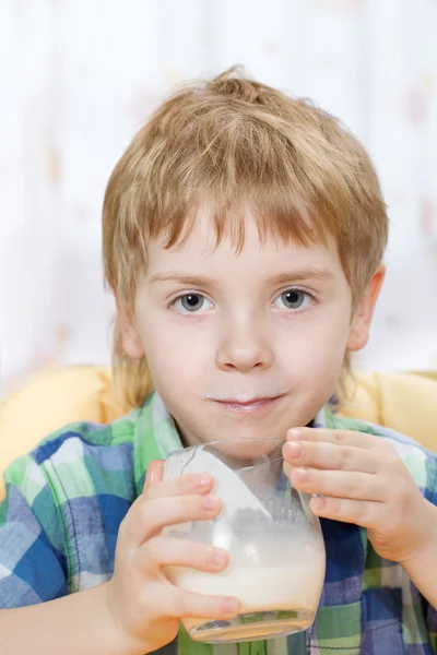 Pojke med mjölk mustasch efter dricka ur glas — Stockfoto