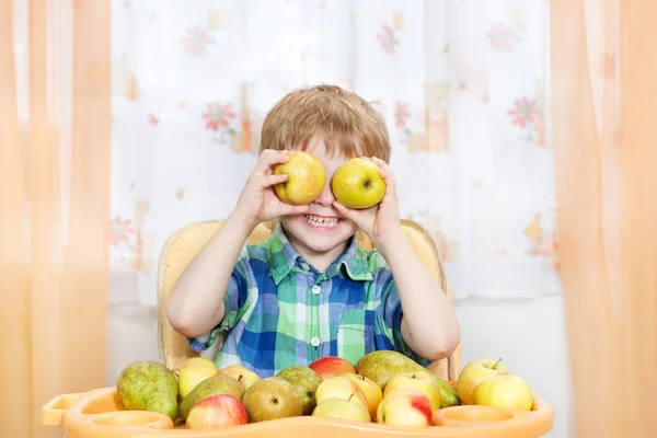 Menino feliz brincando com maçãs com frutas . — Fotografia de Stock
