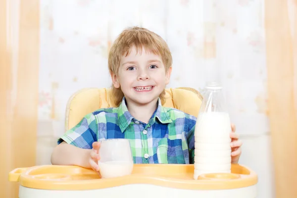 子は牛乳を飲みます。ミルクのガラスを保持しています。 — ストック写真