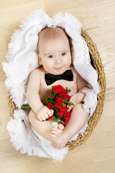 Adorabile bambino che tiene i fiori e indossa cravatta farfalla, sdraiato i — Foto Stock