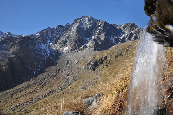 Cima di pietra rossa s malým vodopádem, národní park stelvio — Stock fotografie