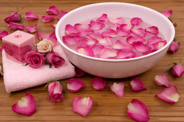 Свіжі яскраво-рожеві троянди, пелюстки, свічки та рушник у спа-центрі — стокове фото