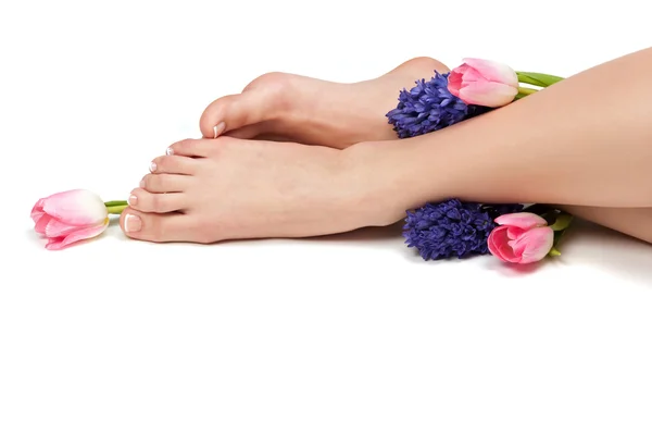 Pedicured feet and aromatic flowers Royalty Free Stock Photos
